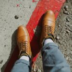 Bottillons homme RODNEY en cuir couleur cognac, portés par un homme avec pantalon revers