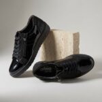 Baskets femme avec fermeture éclair Volt en cuir vernis noir, photographie studio