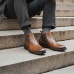 Chelsea boots pour homme modèle EDGER en cuir couleur cognac. Image lifestyle d'un homme assis portant ces chelsea boots. Collection ARIMA CITY