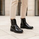 Boots vernis noir en cuir, modèle LOU, image lifestyle d'une jeune femme portant ces boots. Collection REBELLES